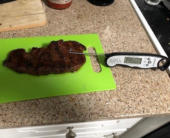 The meat thermometer being used on a steak