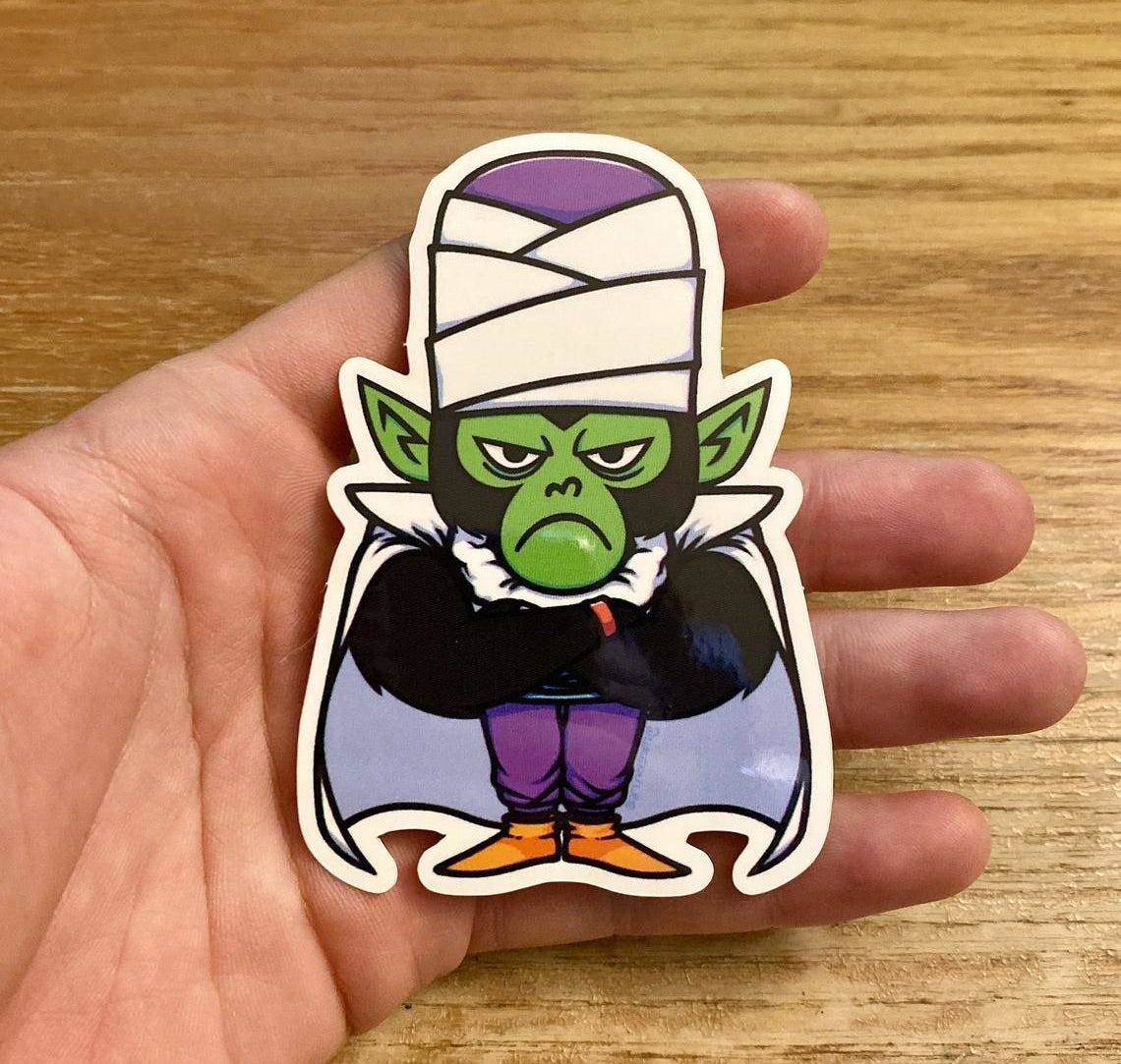 a person holding a palm-sized mojo jojo sticker