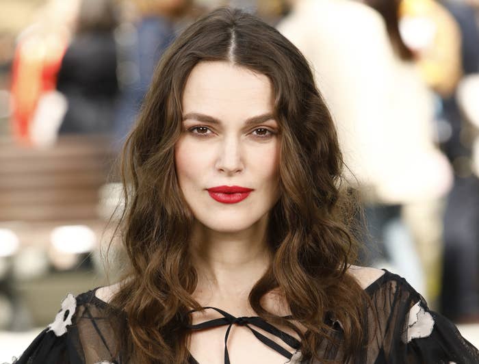 Keira wears a bold red lipstick while posing at an event