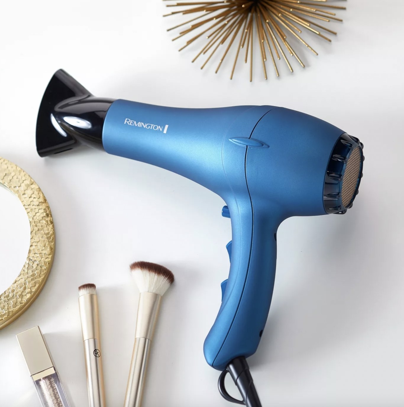 A blue blow-dryer with makeup brushes and a mirror