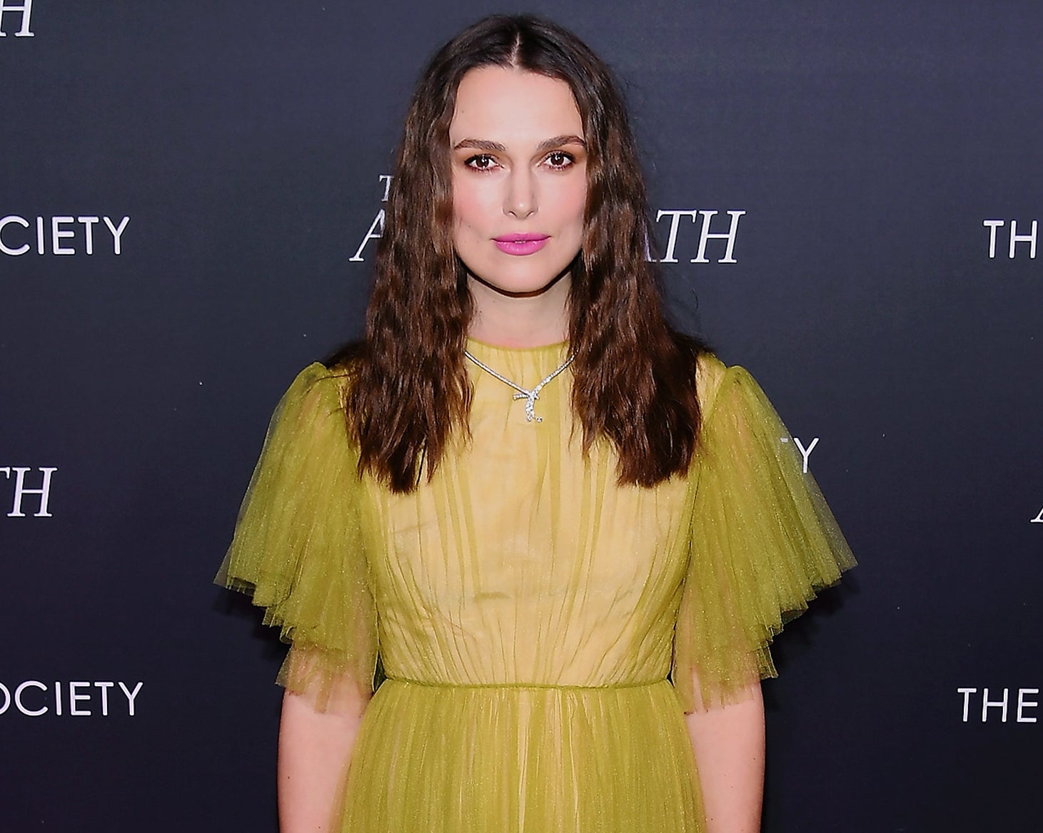 Keira wears a yellow dress with tulle sleeves while attending an event