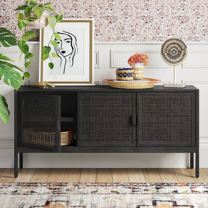 The black wooden sideboard with three mesh doors