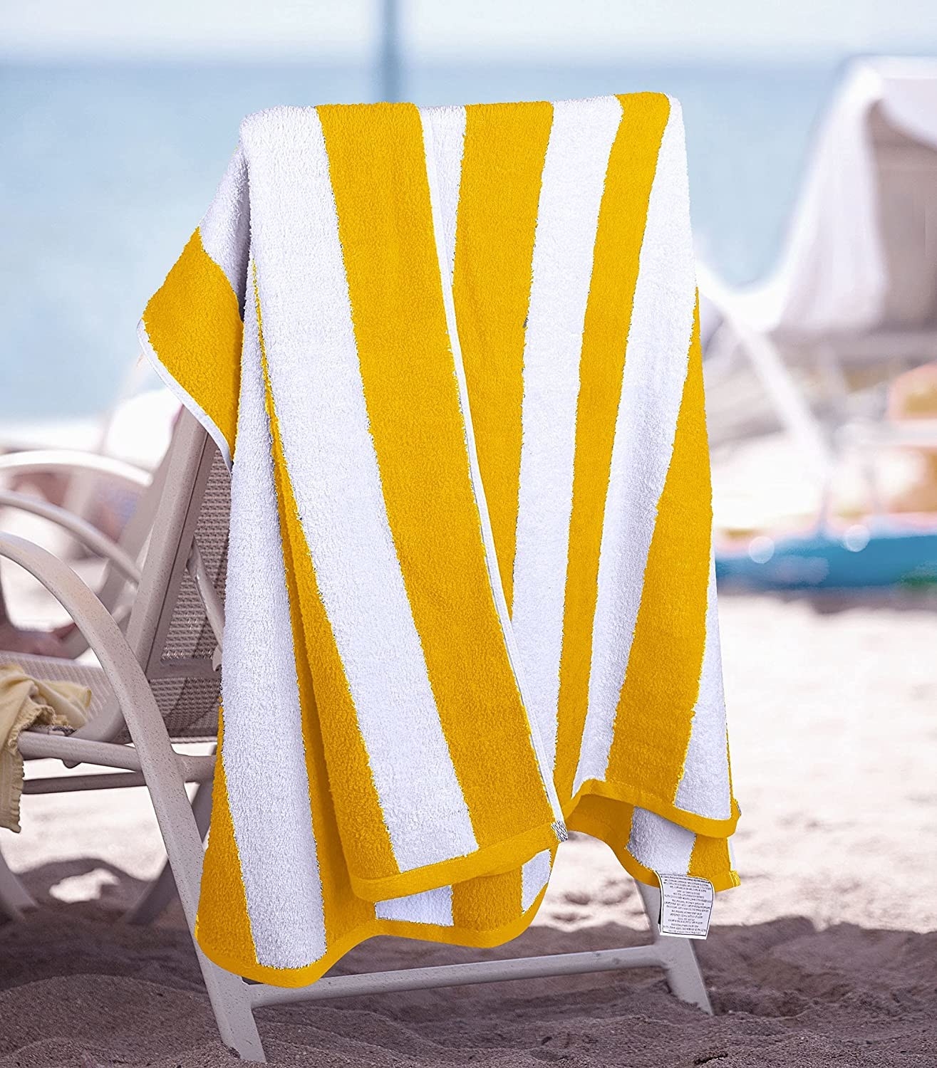 yellow beach towel hanging on the back of a chair