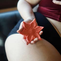 Model holding star-shaped vibrator curved in palm