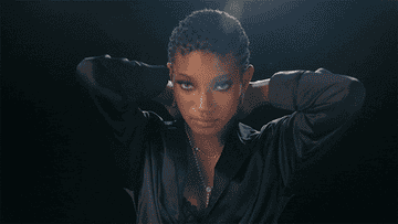 Willow Smith reaches towards the camera and then pulls her arms behind her head