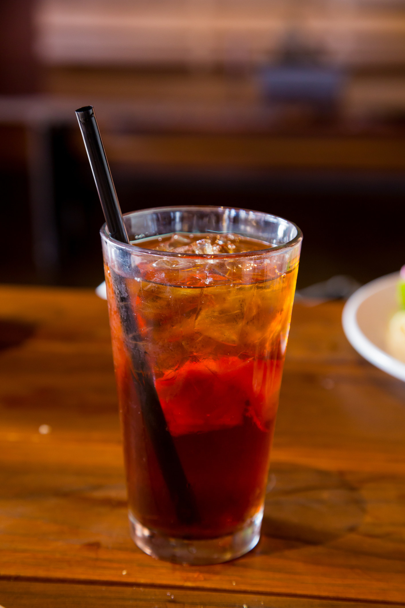 Long Island iced tea with a fruit on a bar top