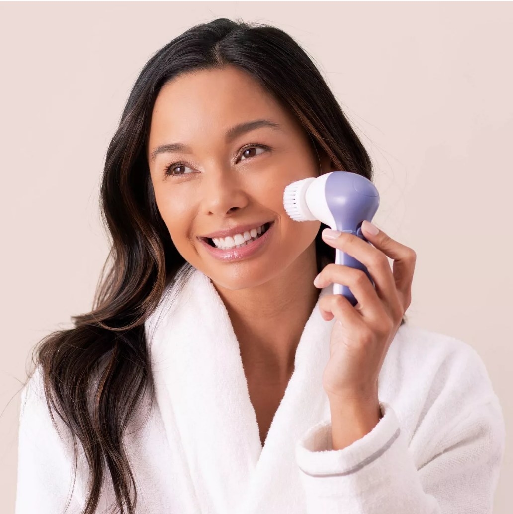 A model using an electric facial cleansing brush