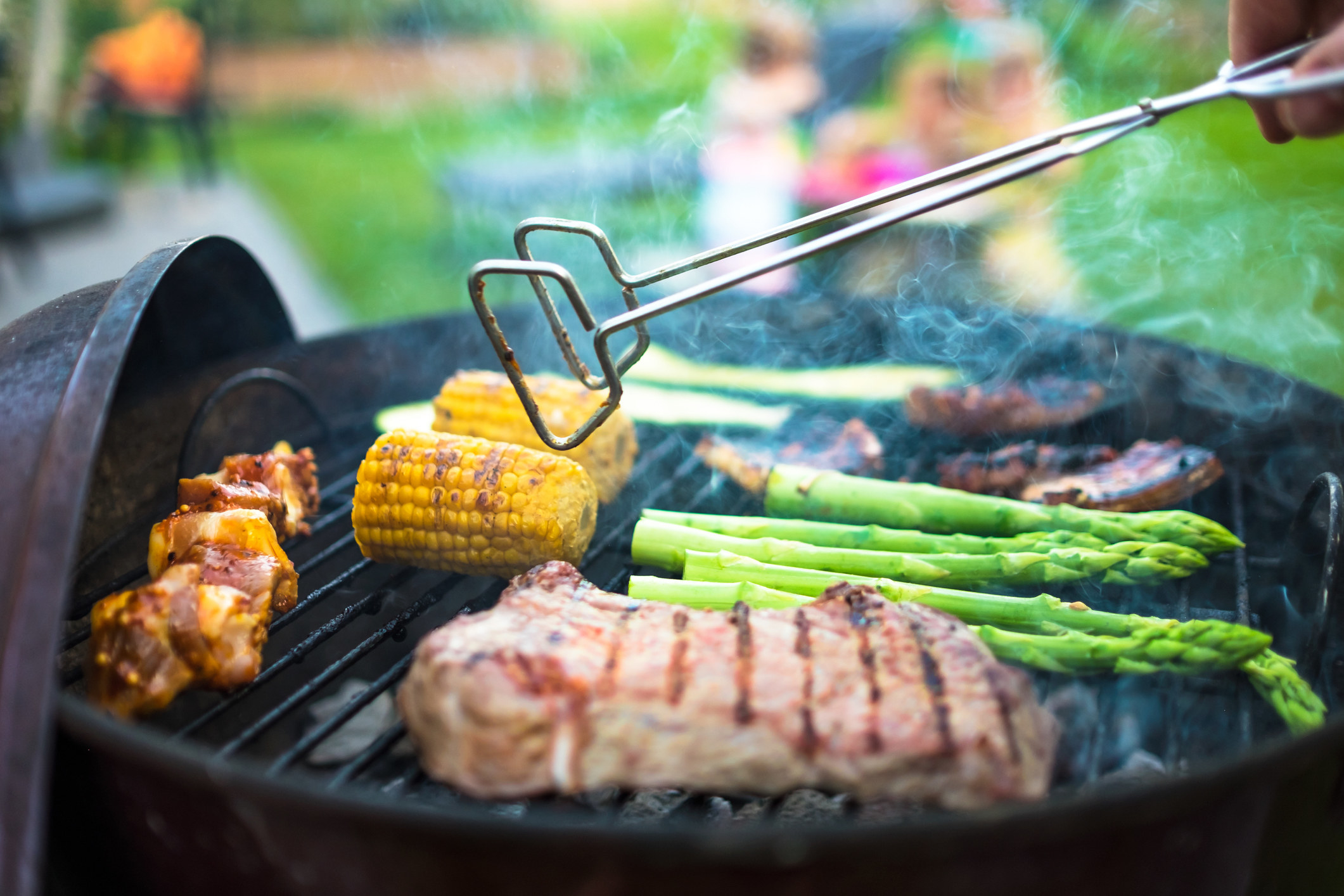 Cooking chicken and vegetables on a grill.