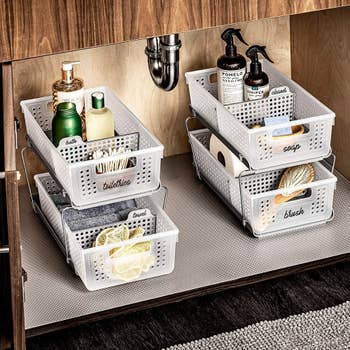 two storage towers with bath products sitting underneath a sink