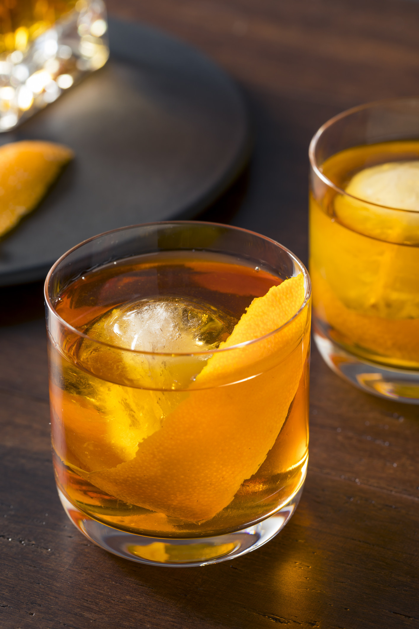 A short glass of old fashioned with a slice of orange