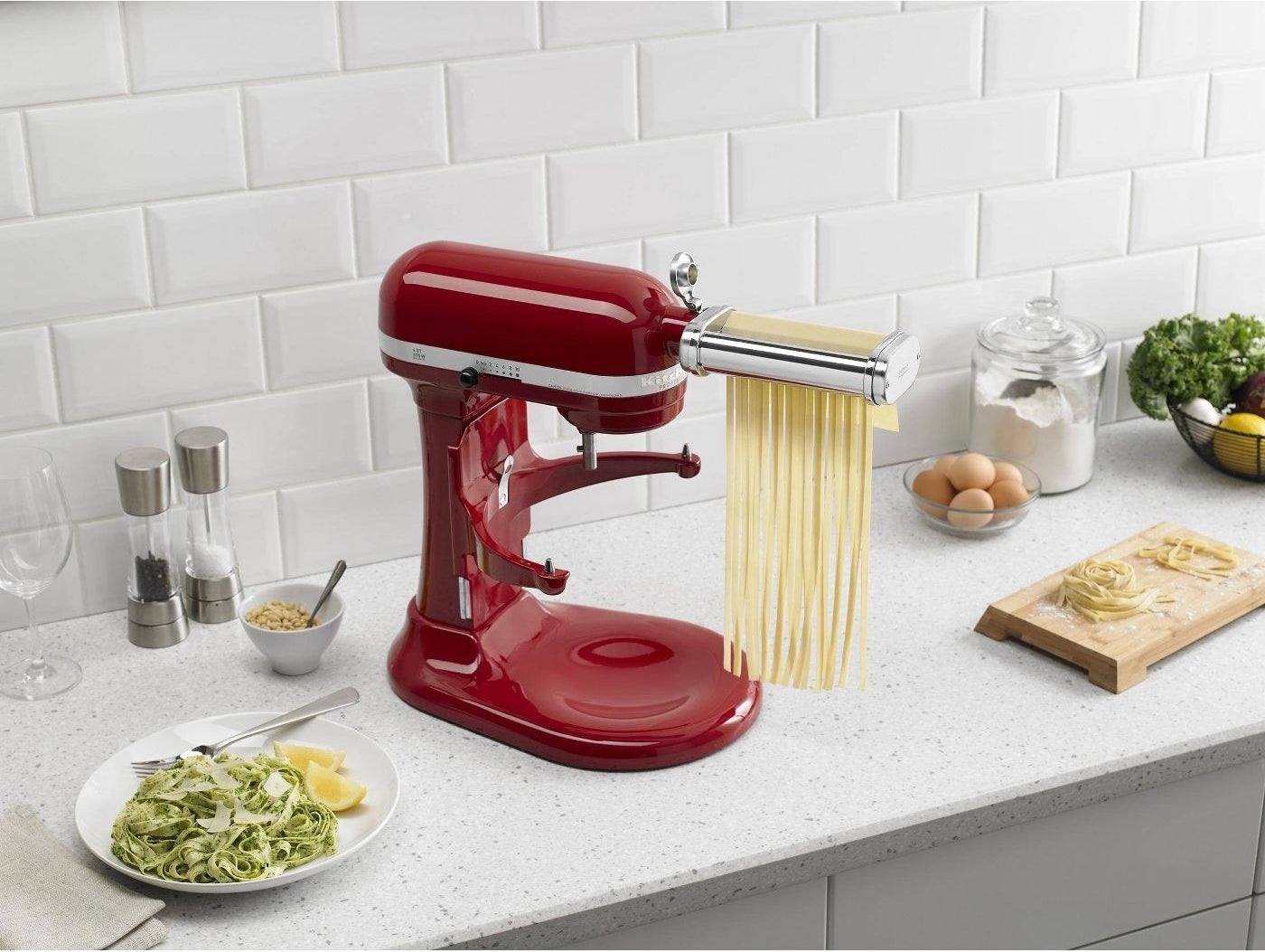 a KitchenAid blender with pasta rolling and cutting attachments staged on a kitchen counter