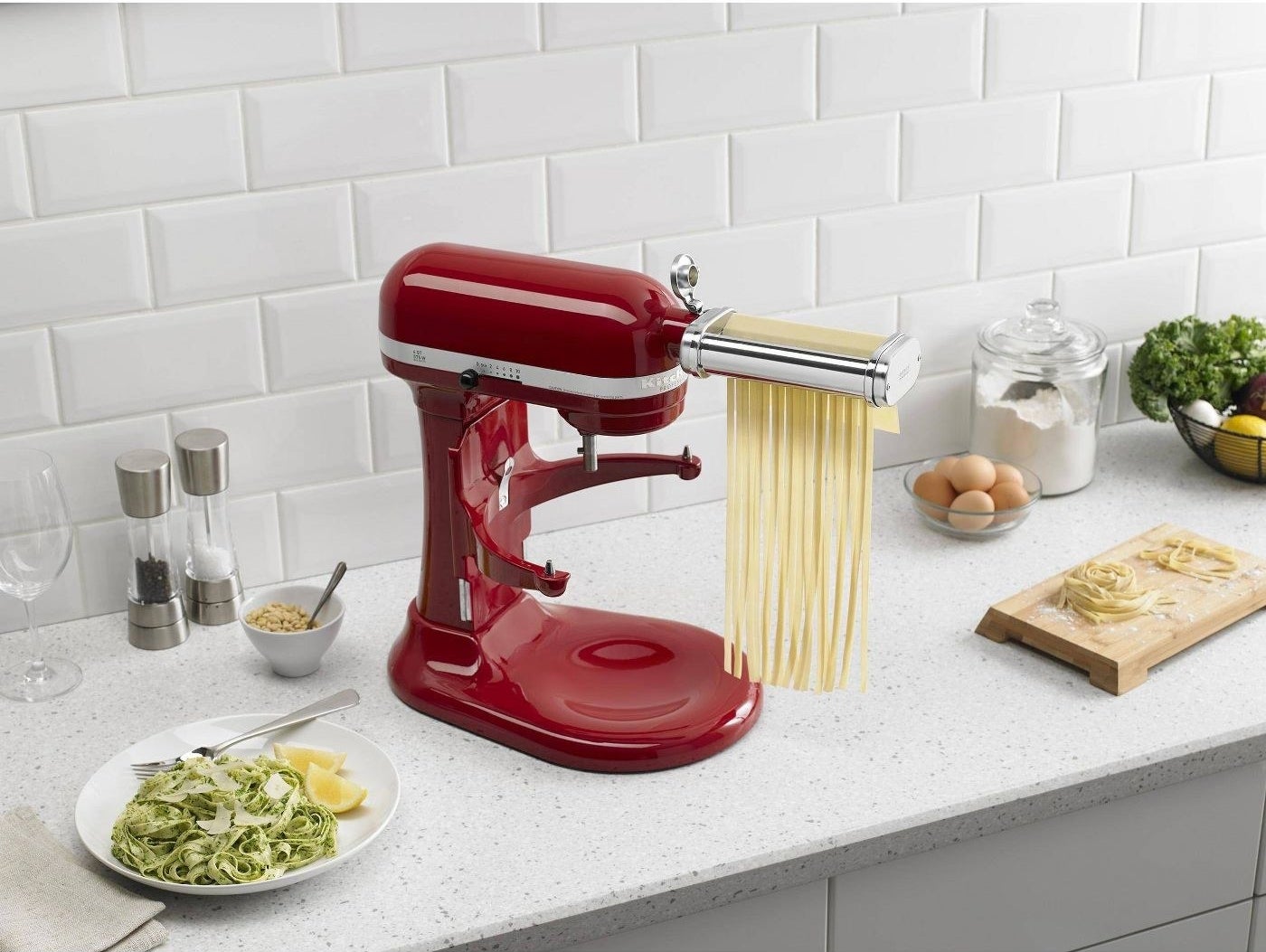 a KitchenAid blender with pasta rolling and cutting attachments staged on a kitchen counter