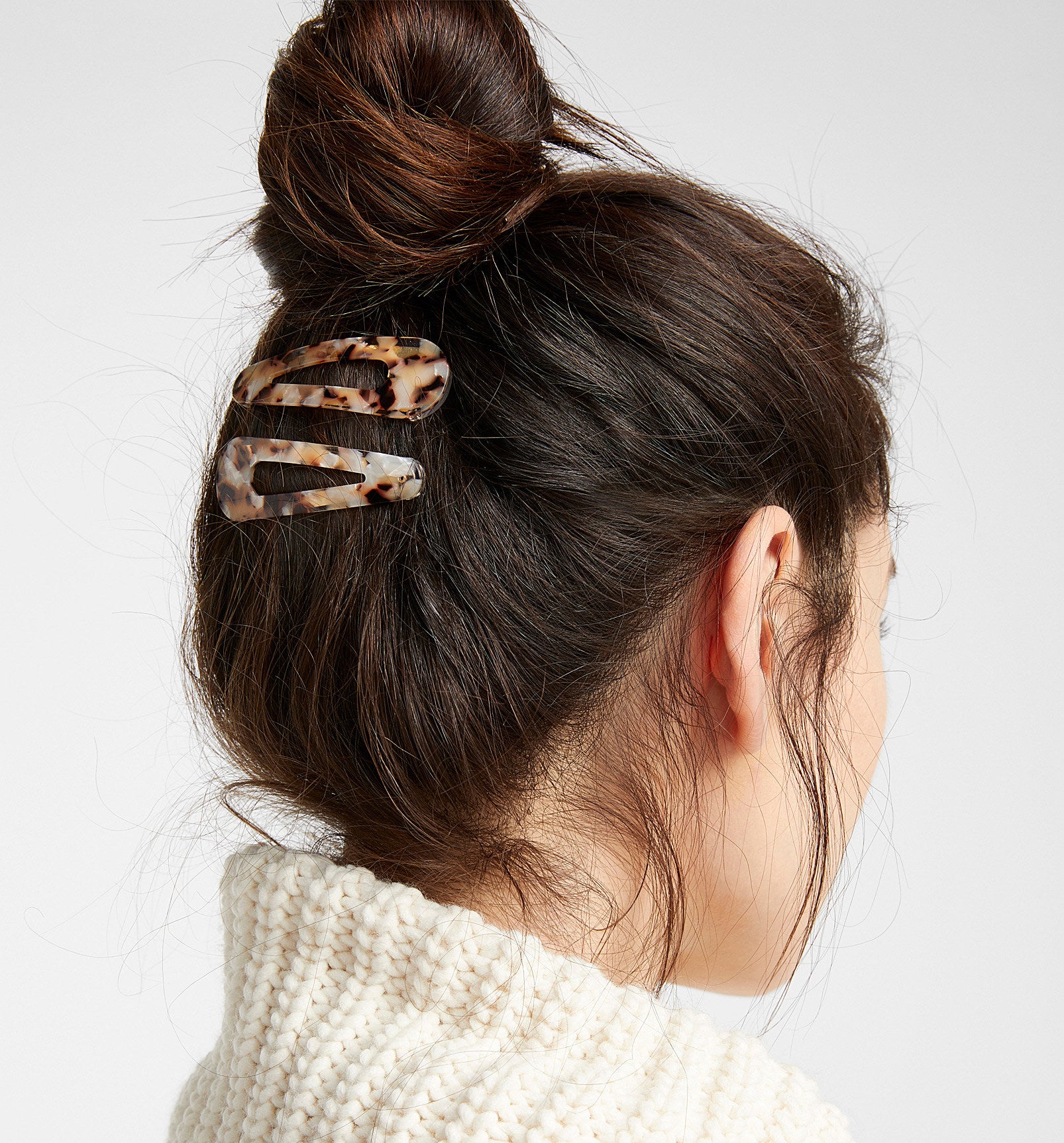 Two matching barrettes snapped onto the underside of someone&#x27;s top bun