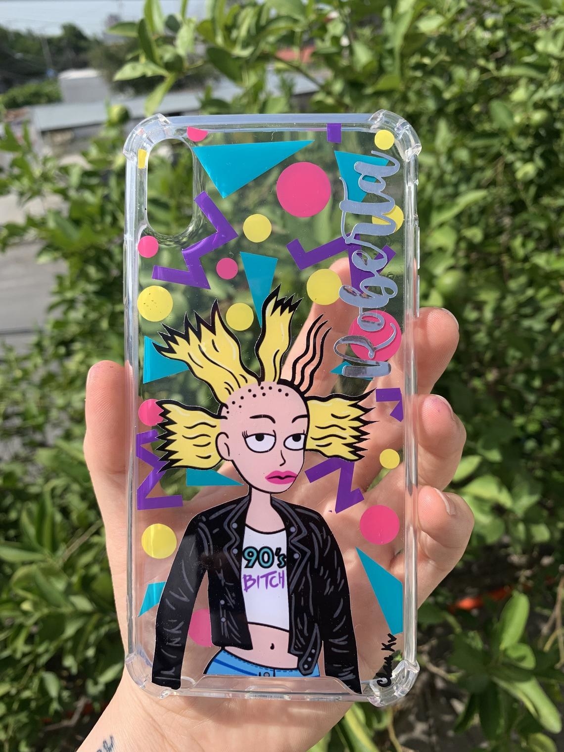 A person holding a colourful phone case with Cynthia wearing a leather jacket on it 