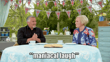 The judges from The Great British Baking Show laughing maniacally at a table