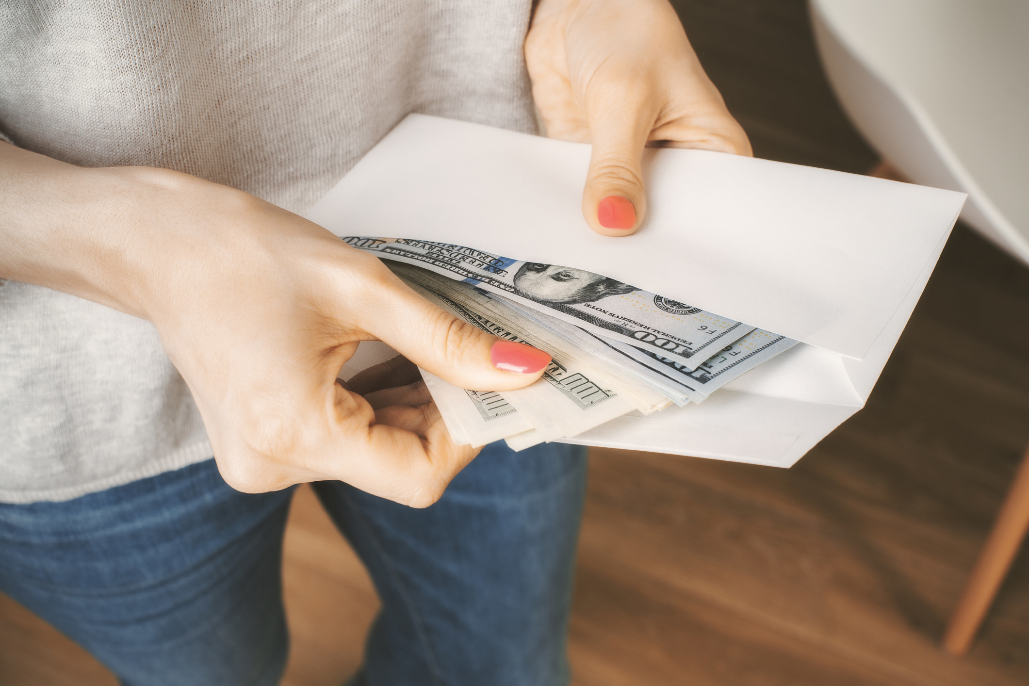 Person holding envelope with cash