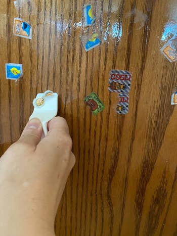 Reviewer's photo showing stickers on a wood cabinet