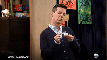 Jack McFarland taps a small spoon on the lip of a tiny tea cup before lifting the cup to his lips.