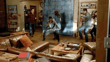 A gif of the new girl cast dancing in the loft 