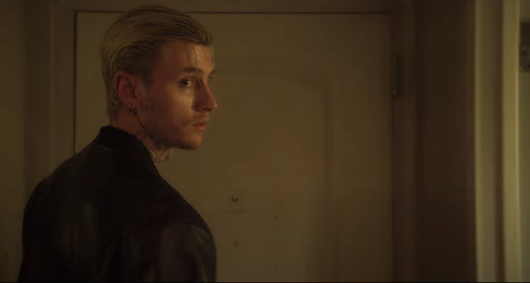 MGK looks back while heading out of a door in a screenshot from the film