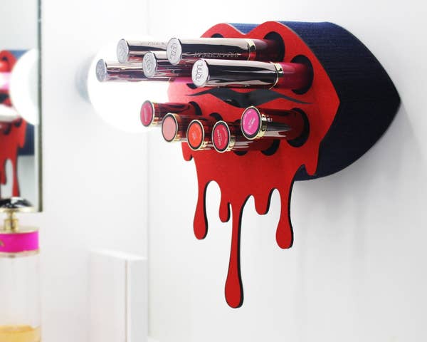 the lip-shaped lipstick holder holding a variety of lipsticks and glosses