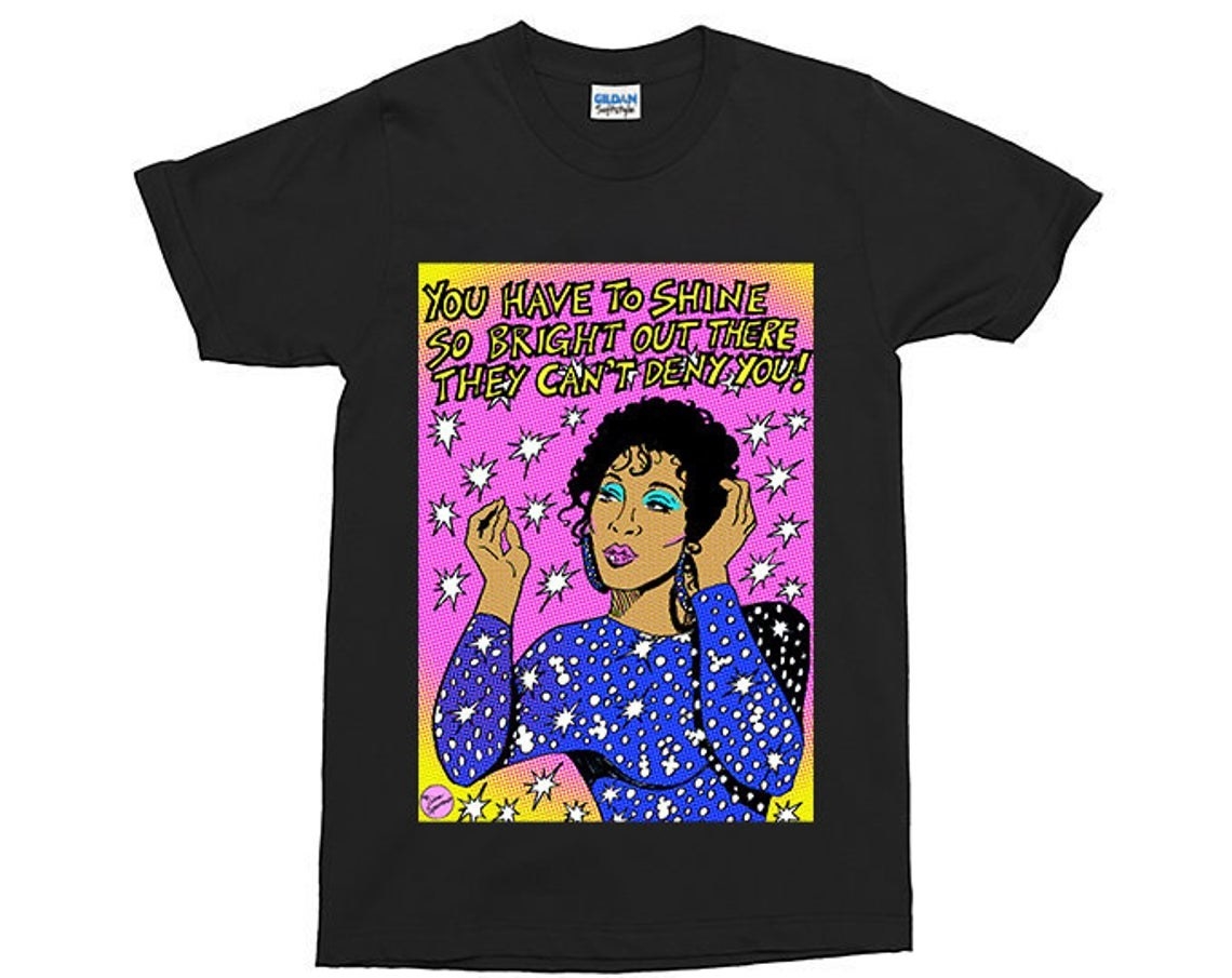 t-shirt with an illustration of Blanca Evangelista with a quote that says, &quot;You have to shine so bright out there they can&#x27;t deny you&quot; 
