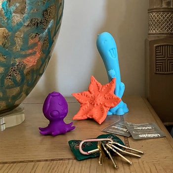 Purple squid vibrator, orange star-shaped vibrator and teal fantasy vibrator sitting on nightstand