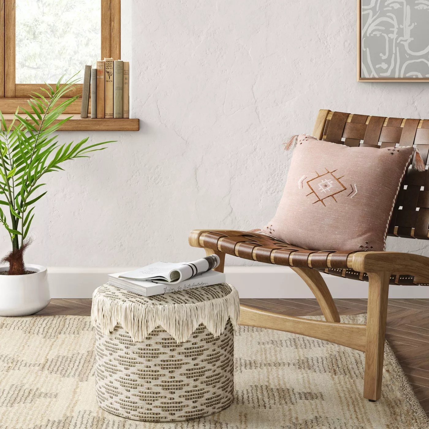 The circular pouf with fringe around the top in a living room