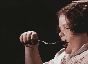 GIF of Bruce eating the cake in Matilda 
