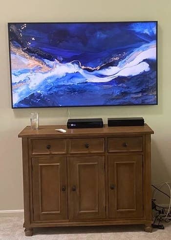 Reviewer TV mounted to wall over furniture