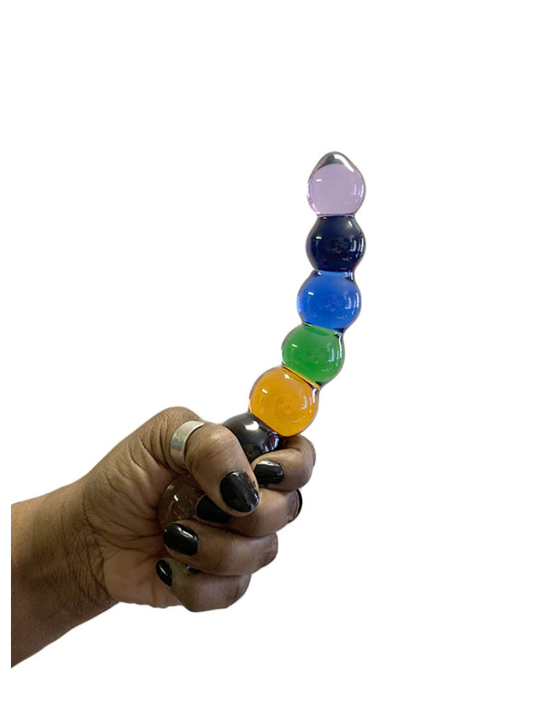 Model holding rainbow glass dildo