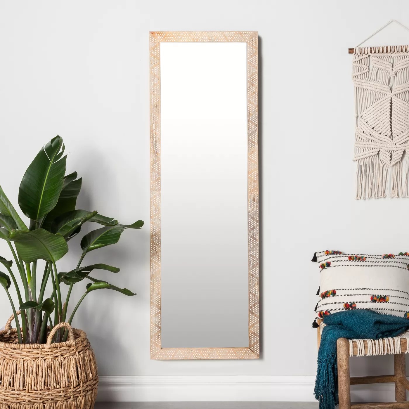 The rectangular mirror with a white dot pattern hanging on a wall in a living room