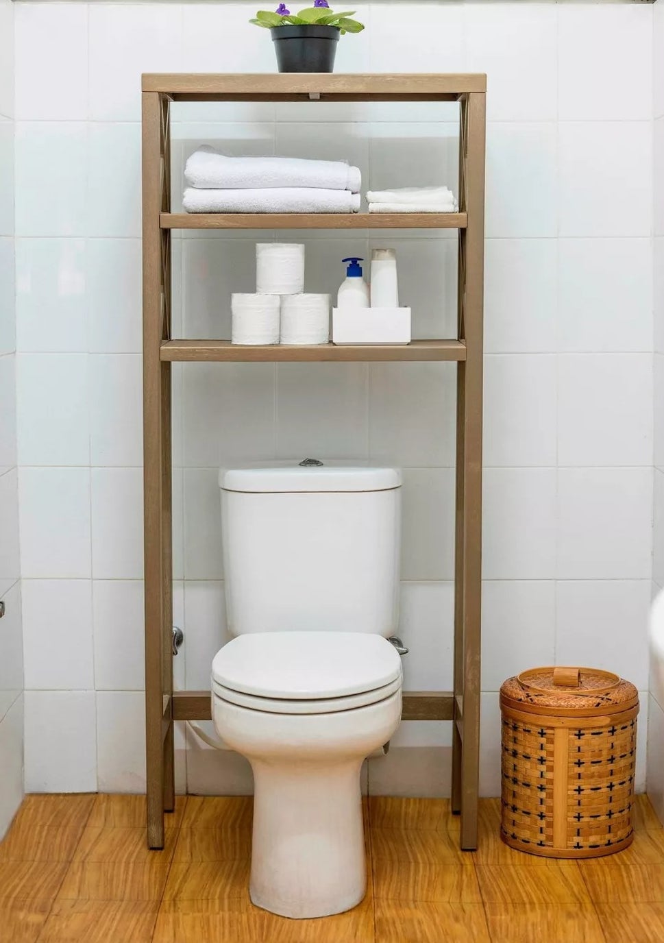 The shelf directly above a toilet in a bathroom