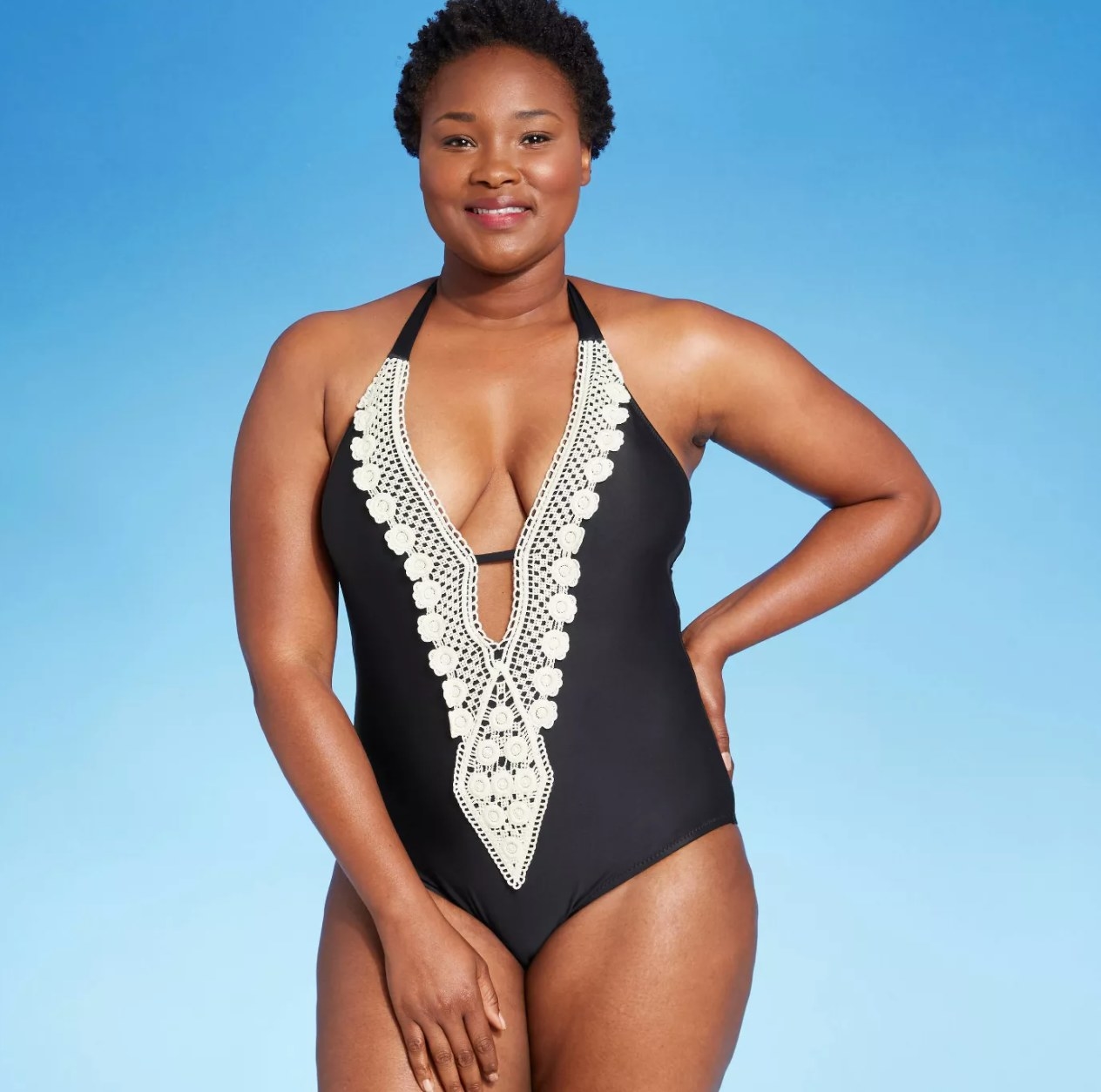 model wearing the black one piece with white crochet 