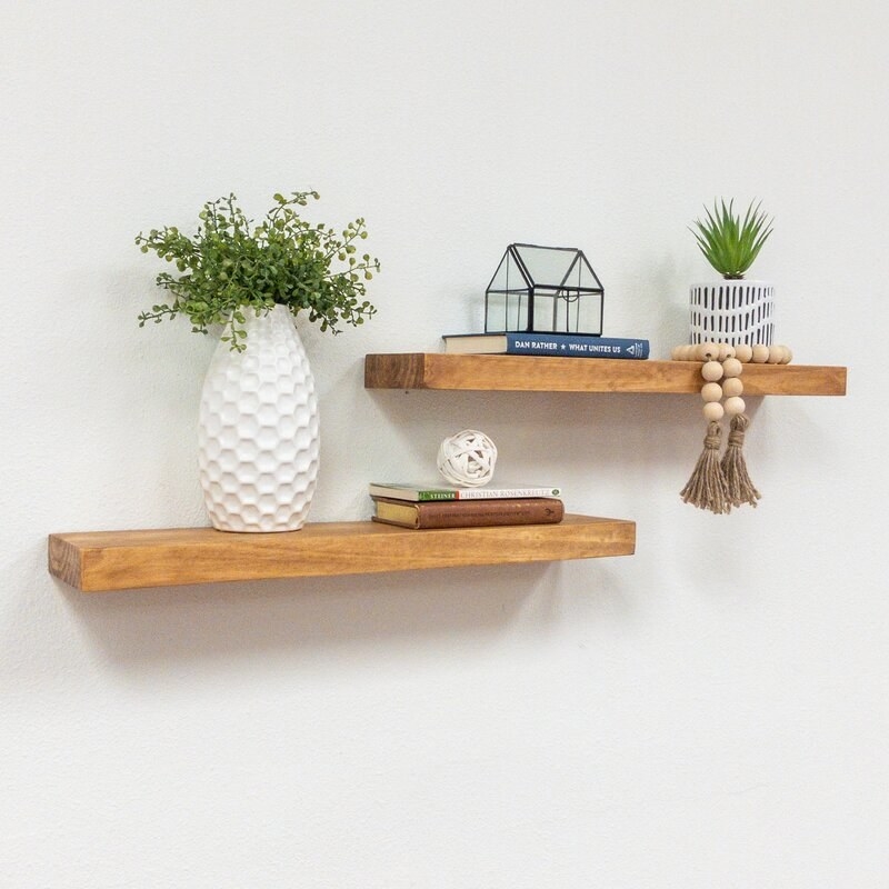 two wood floating shelves with decor on top