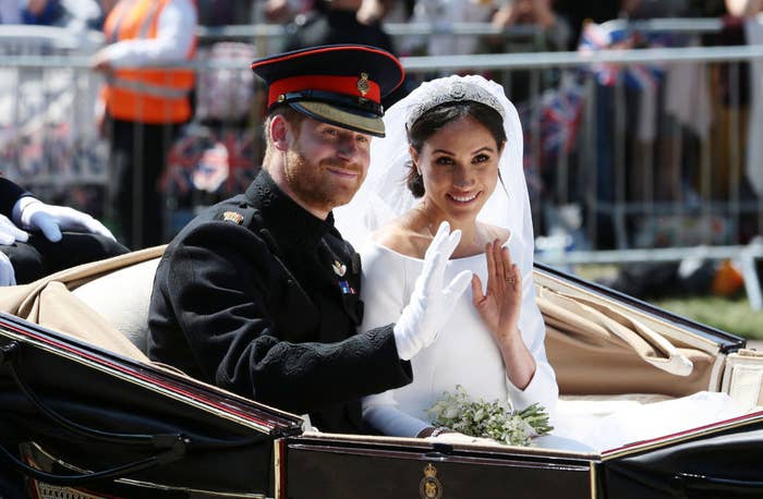 Prince Harry and Meghan Markle wave to crowds on their wedding day while riding in a carriage