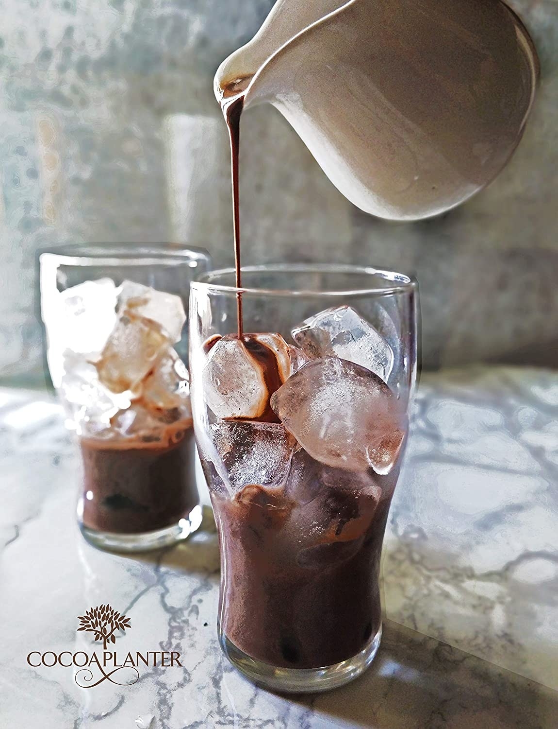 The cocoa mix being poured over ice in a glass.