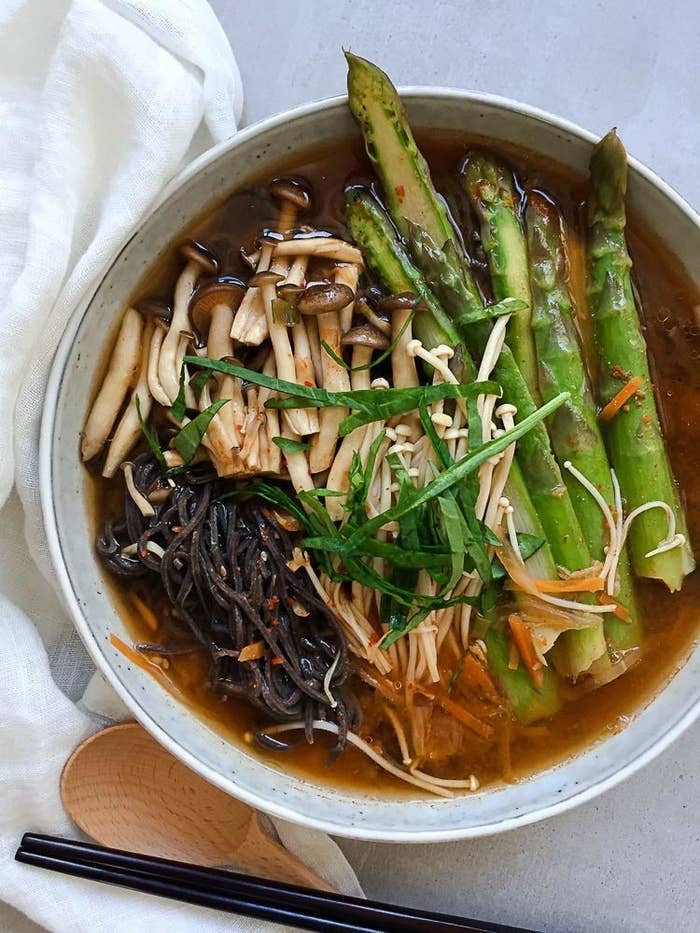 A bowl of miso soup with noodles and vegetables
