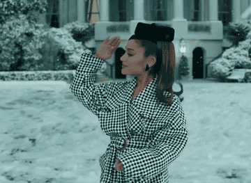 Ariana Grande walks around in a Jackie O–inspired outfit on set of a music video
