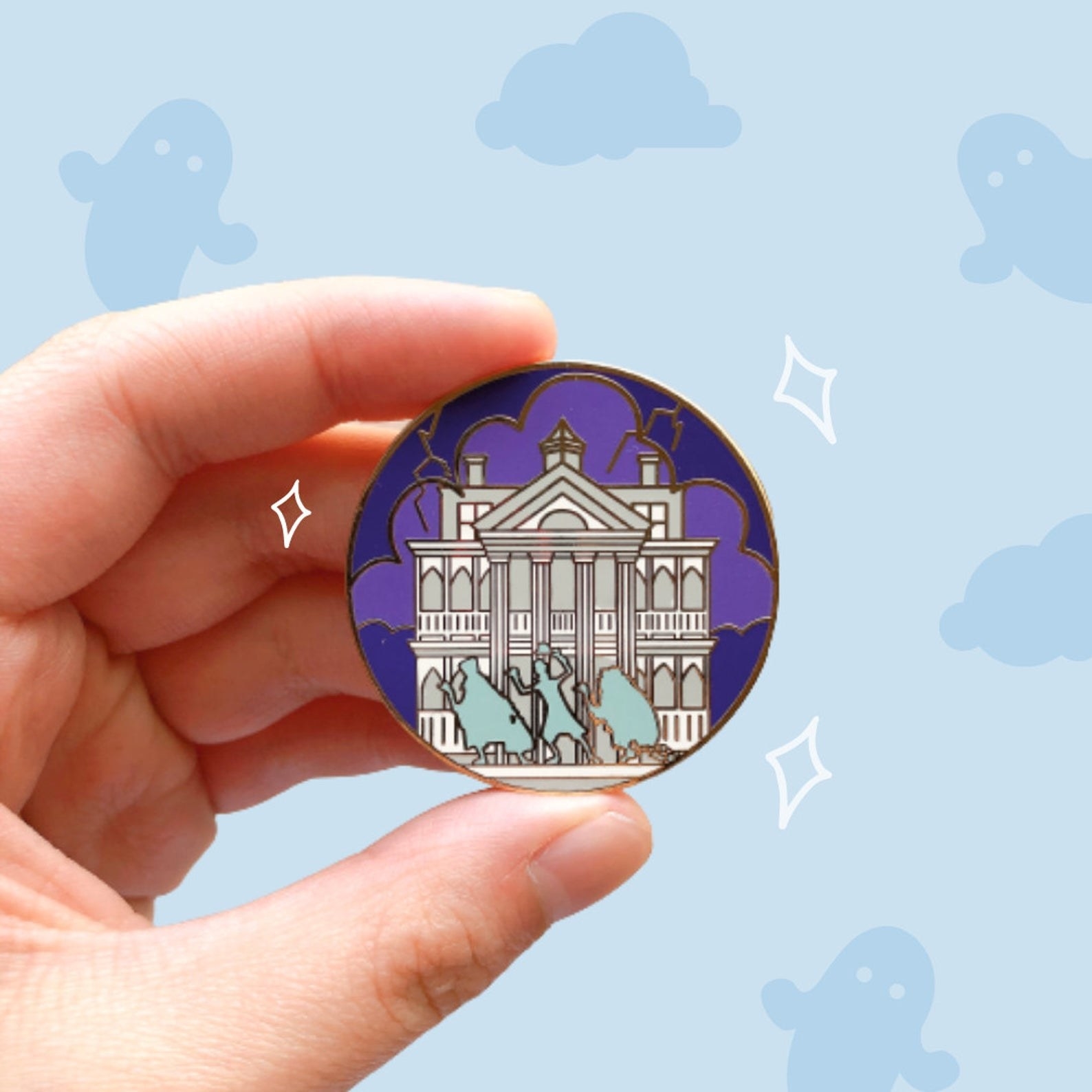 a pin with the haunted mansion on it and the three hitchhiking ghosts