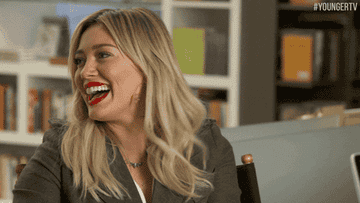Hilary Duff throws her head back then doubles over laughing