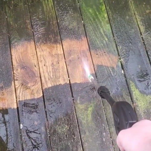 reviewer using an electric power washer to clean a deck