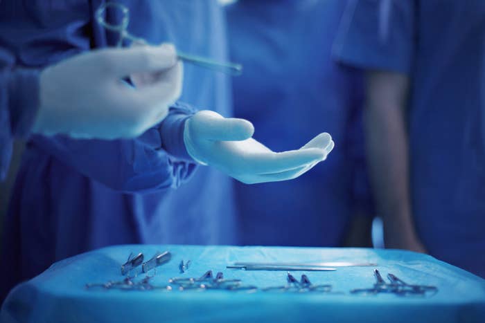 A surgeon holds tools in an operating room
