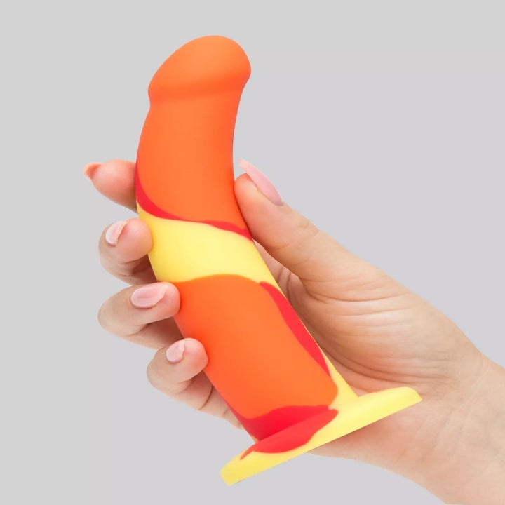 Model holding orange abstract dildo