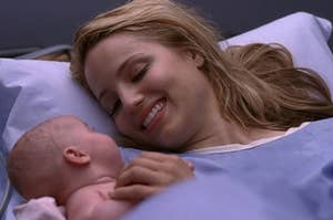 奎因Fabray微笑在她刚出生的女儿躺在医院的床上。