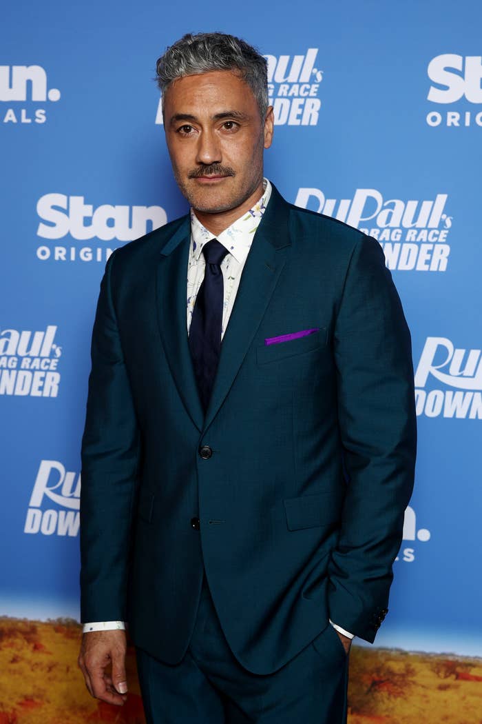 Taika Waititi on the red carpet in a suit and tie