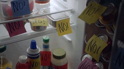 Interior of a refrigerator with post-it notes that say no stuck to all the food
