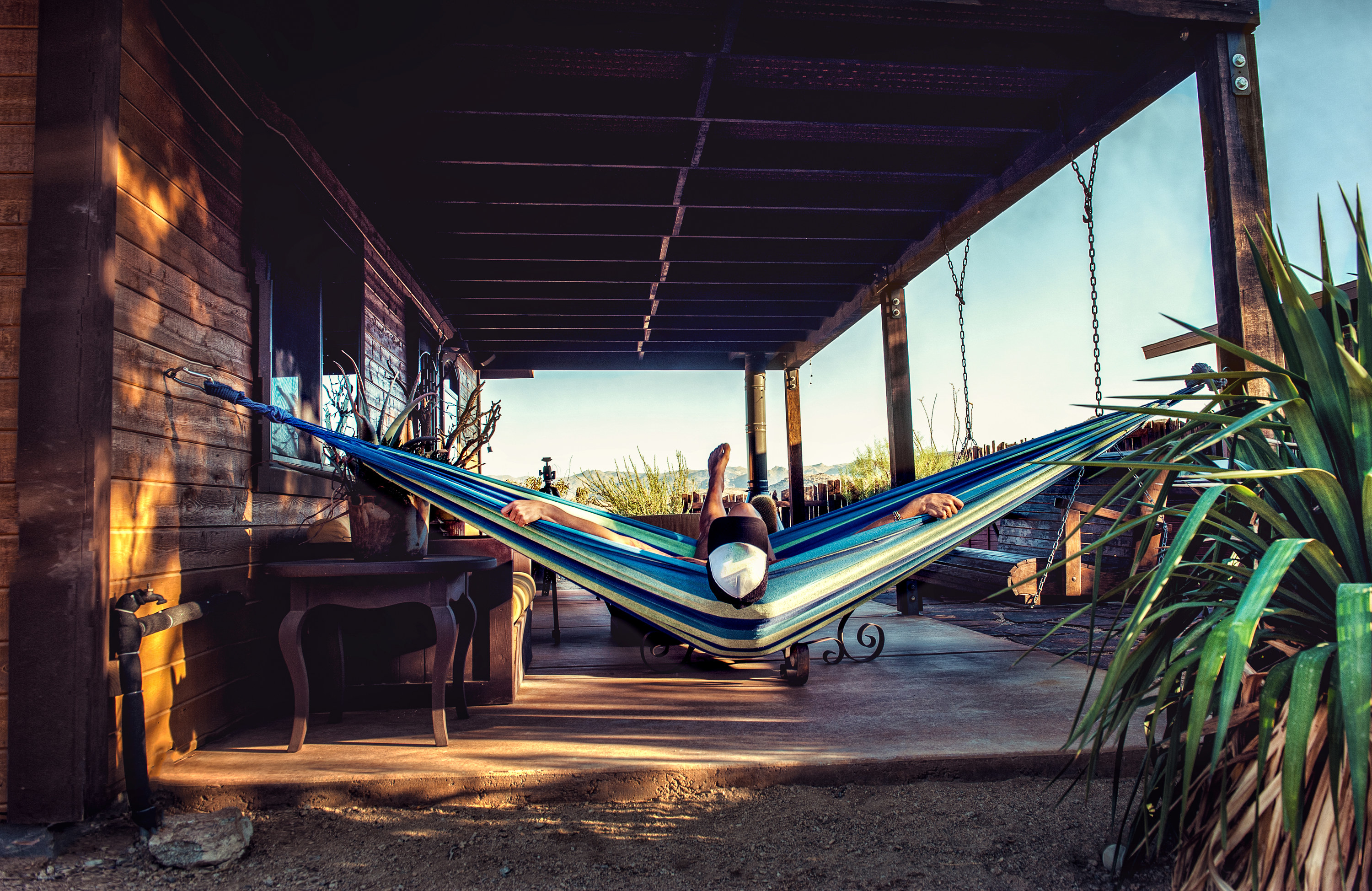 Person relaxing in a hammock outside a cabin in Joshua Tree
