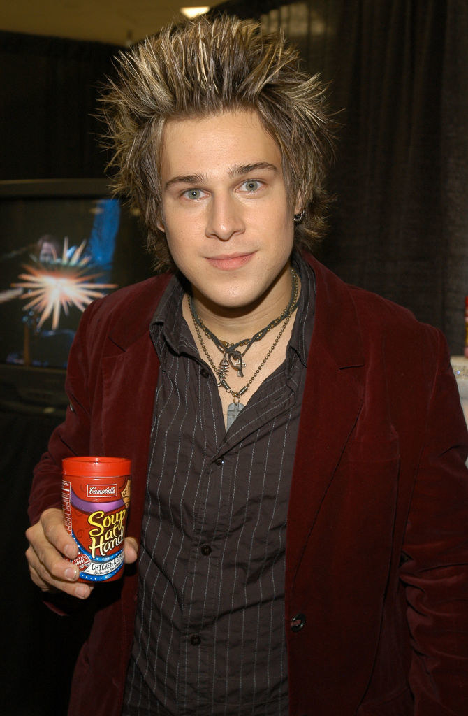 ryan in a red blazer holding campbells soup at hand