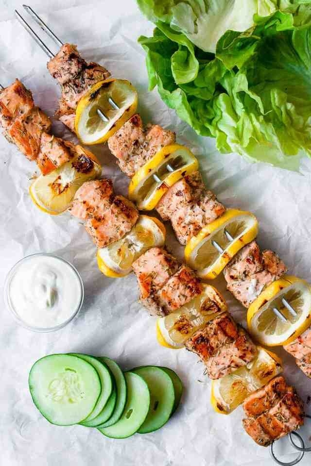 Grilled salmon kebabs with cucumber slices and lemon